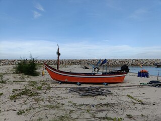 Fototapeta premium This captivating image portrays a serene scene of a boat gently floating on the sea as the sun sets on the horizon.