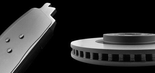 Car brake disc and brake pads isolated on black background. Auto spare parts. Perforated brake disc...