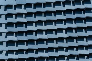 Geometric pattern of building facade with shadows in urban setting.