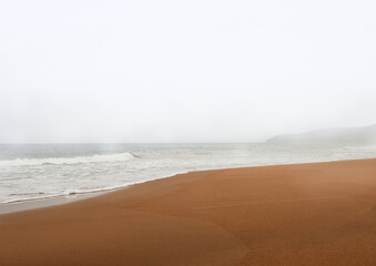 Golden beach on a stormy misty day