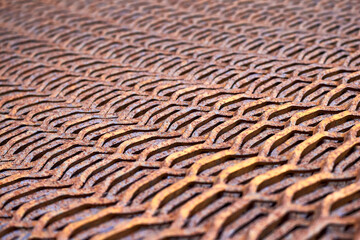 Perforated rusty metal floor sheet stamping plates texture closeup angled view. Metal stamping sheet metal manufacturing lightweight bearing flooring elements structural combine strength functionality