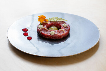 Gourmet beef tartare plating, fine dining presentation, modern restaurant dish with edible flower