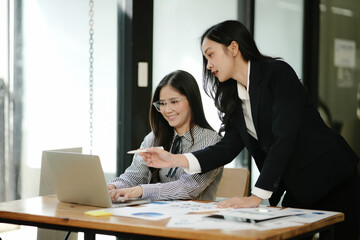 Asian business woman talking, working on graph documents