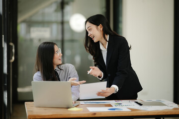Asian business woman talking, working on graph documents