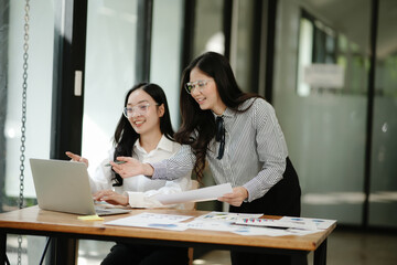 Asian business woman talking, working on graph documents