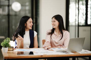 Fototapeta premium Asian business woman talking, working on graph documents