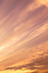 Obraz premium Sky with soft and fluffy pastel orange pink and blue colored clouds. Sunset background. Nature. sunrise. Vertical