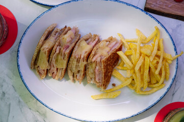 Three grilled ham and cheese sandwiches with fries.