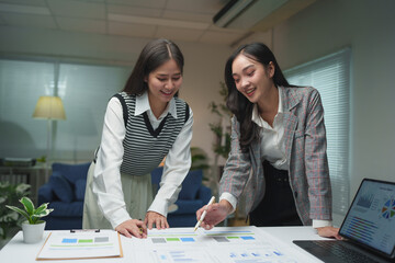 .Teamwork process. Two business women calculating a valuation in the workplace. laptop on the table, typing keyboard, analysis of earnings, analyzing graph plans