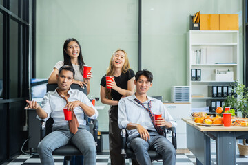 Asian business team are excited business success with inspiration from their excellent financial results, celebration successful deal with champagne and pizza in the workplace.