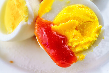 Boiled egg with ketchup and salt.