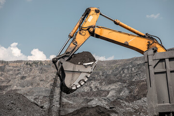 Large quarry dump excavator. Big yellow mining excavator at work site. Loading coal into body...