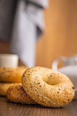Bagel sprinkled with fried onion, sesame and poppy seeds on wooden table.