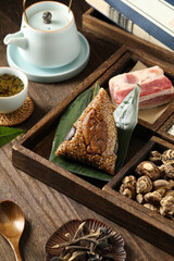 Traditional Chinese rice dumplings with pork and mushroom fillings on a wooden table