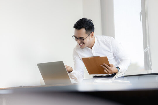 Mature business man executive manager looking at laptop computer watching online webinar training or having virtual meeting video conference taking notes, doing market research working in office.