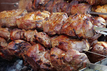 Big fat shish kebabs broils in barbecue. Fatty, unhealthy, partially burnt meat