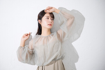 Fototapeta premium 肌に艶(ツヤ)感と透明感のある若い女性の日差しや美容やビューティーのイメージのアンニュイな表情