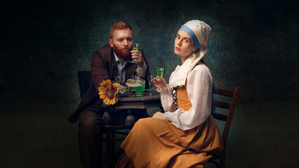 Man and woman dressed in vintage clothing sit at table, drinking alcohol drinks. Mix of rustic charm with historical atmosphere. Concept of art, eras comparison, creative vision, ad