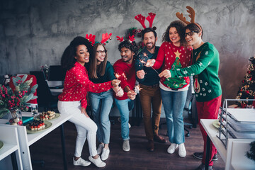 Photo of cheerful young people colleagues cheerful have fun bengal light cozy christmas party decor...