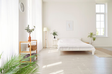 Empty, cozy bedroom with a comfortable white bed in a house or home. The peaceful interior creates a sense of comfort and warmth in the home during a quiet morning, inviting relaxation and rest.