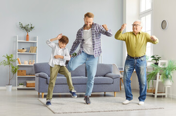 Positive grandfather, father, and son spending leisure time dancing to music at home. They enjoy...
