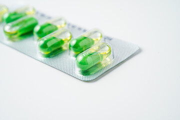 transparent gelatin capsules on white background..Oil filled blister pack green softgel food supplements