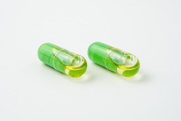 Transparent capsules with a mixture of green powder and oil, Food supplements, vitamins