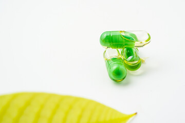transparent pills with a mixture of green powder and oil, Food supplements, vitamins and minerals