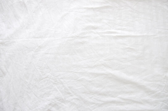 Top view of wrinkles on an unmade bed sheet after waking up in the morning.