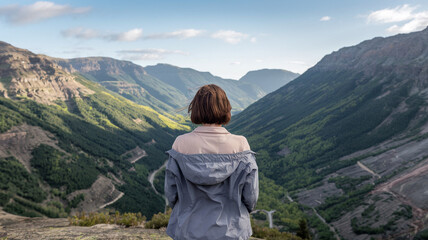 Naklejka premium Woman Gazes at Mountainous Landscape From Peak