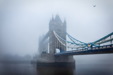 Moody view of the Tower Bridge of London, England, during a foggy autumn day