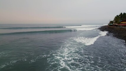 El Salvador beach zooming drone shot close to crashing waves at Punta Roca in La Libertad, place where world class surf competitions are held - dolly in