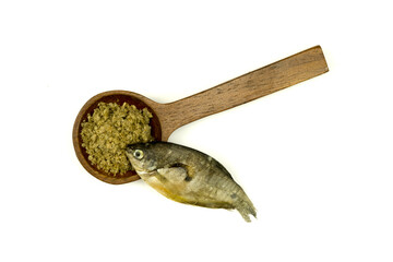 Dried fermented fish whole and mashed in wooden spoon isolated on white background  top view flat...