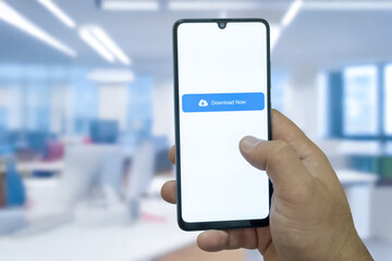 Close-up of “Download” message on smartphone screen. Online file download concept. Office background. Download message. 