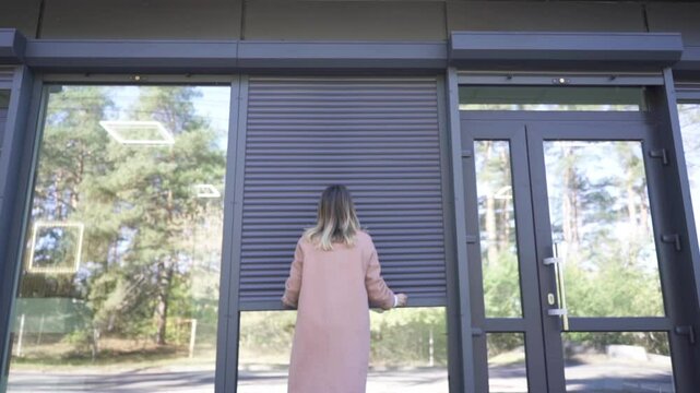 Female Business Owner of Local Store opening garage storefront