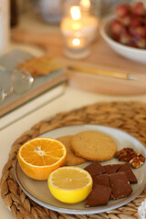 Pumpkins, various food and drinks, fall decorations, books and candles on the table. Fall hygge at home. Selective focus.