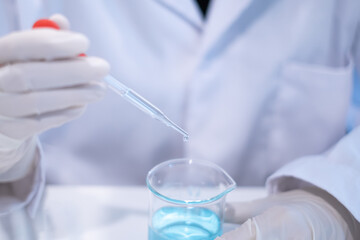 Fototapeta premium Scientist pipette doppler blue liquid in test tube beaker laboratory science biotechnology biology chemistry medical pharmaceutical DNA medical healthcare research discovery innovation experiment