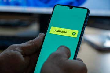Close-up of “Download” message on smartphone screen. Online file download concept. Office background. Download message. 