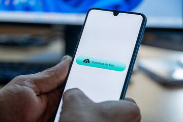 Close-up of “Download” message on smartphone screen. Online file download concept. Office background. Download message. 