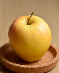 One single apple on centerpiece cork tray