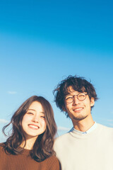 Obraz premium 青空とアジア人カップル、日本人、男女、笑顔、夕日