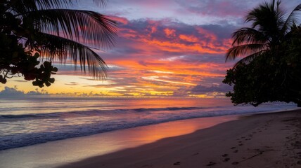 Fototapeta premium Tropical sunset over the beach with palm trees silhouetted against the colorful sky