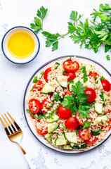 Middle Eastern salad with bulgur, tomatoes, cucumbers and parsley.. White background, top view