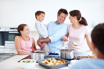 Family, excited and cooking in kitchen with support, Thanksgiving celebration and love. Parents, children and happy in home for meal preparation, nutritional lunch and smile in apartment for learning