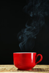 Cup of drink with steam on black background