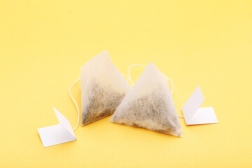 Tea bags on yellow background