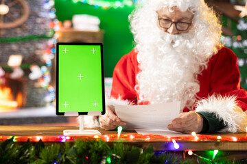 Santa Claus checking his naughty or nice list next to isolated mockup, preparing for his journey...