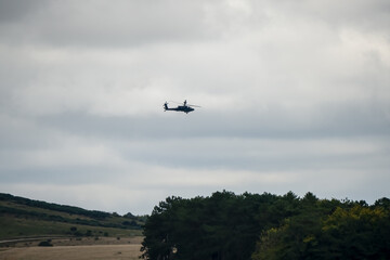 British army Boeing Apache Attack helicopter gunship AH2 AH64E AH-64E ArmyAirCorp in low level flight over countryside