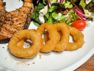 Grilled salmon steak with organic salad and fried onion ring. Healthy food. Seafood. Protein