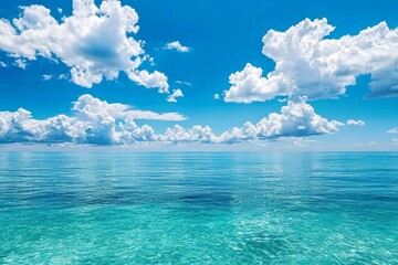 A serene scene of the clear blue sky and turquoise ocean, with fluffy white clouds in the background. The water is crystal clear, reflecting the vibrant colors of the sky above it. 